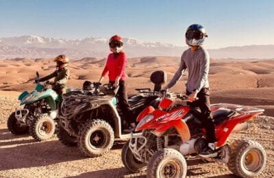 A rider on a quad bike speeding through the rocky terrain of the Agafay Desert with stunning desert landscapes in the background.