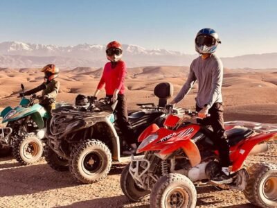 A rider on a quad bike speeding through the rocky terrain of the Agafay Desert with stunning desert landscapes in the background.