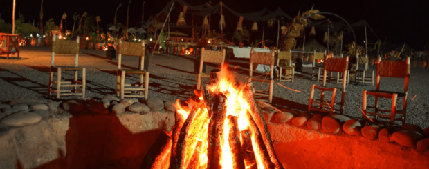 Fire performer showcasing an exciting fire show in the Agafay Desert at night.