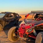 Two Can-Am Maverick buggies parked in the Agafay Desert at sunset during an off-road adventure