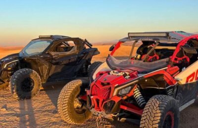Two Can-Am Maverick buggies parked in the Agafay Desert at sunset during an off-road adventure