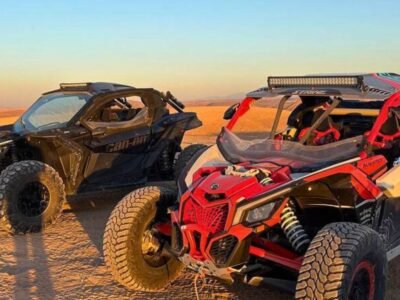 Two Can-Am Maverick buggies parked in the Agafay Desert at sunset during an off-road adventure