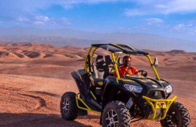 Driver enjoying a buggy ride through the Agafay Desert near Marrakech with panoramic rocky landscapes.