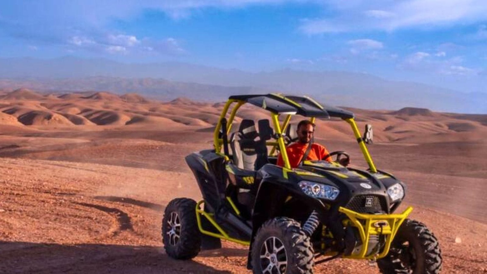 Driver enjoying a buggy ride through the Agafay Desert near Marrakech with panoramic rocky landscapes.